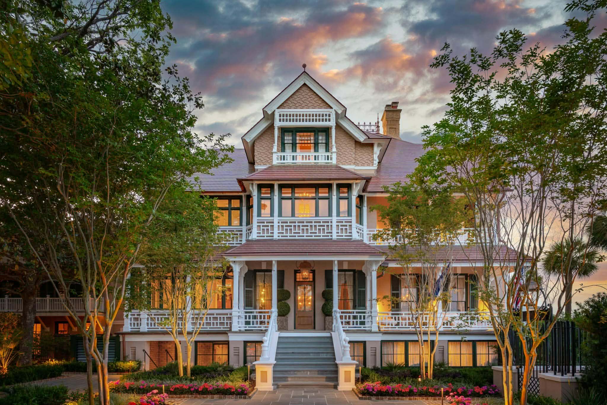 Grand Southern mansion at dusk with warm lights glowing through tall windows